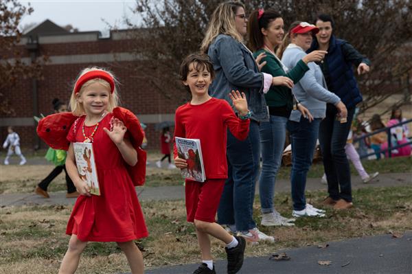 students walking in red costumes